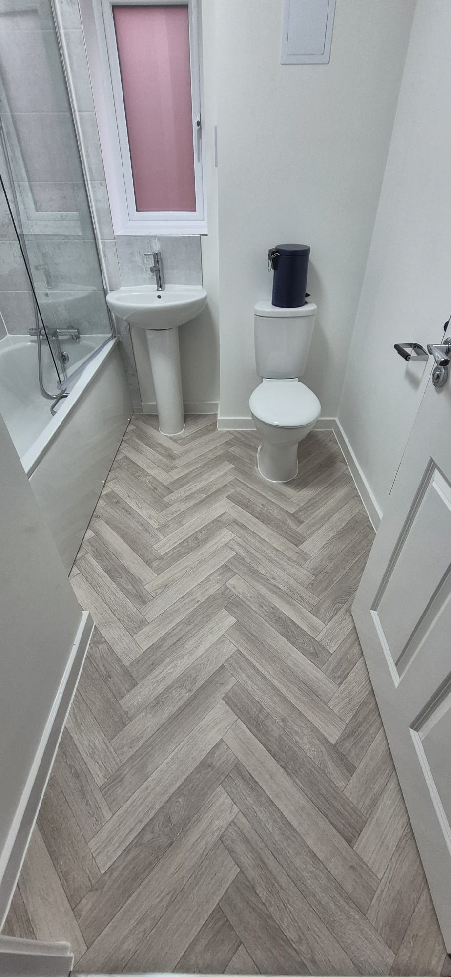 Light oak herringbone vinyl flooring fitted in a bathroom