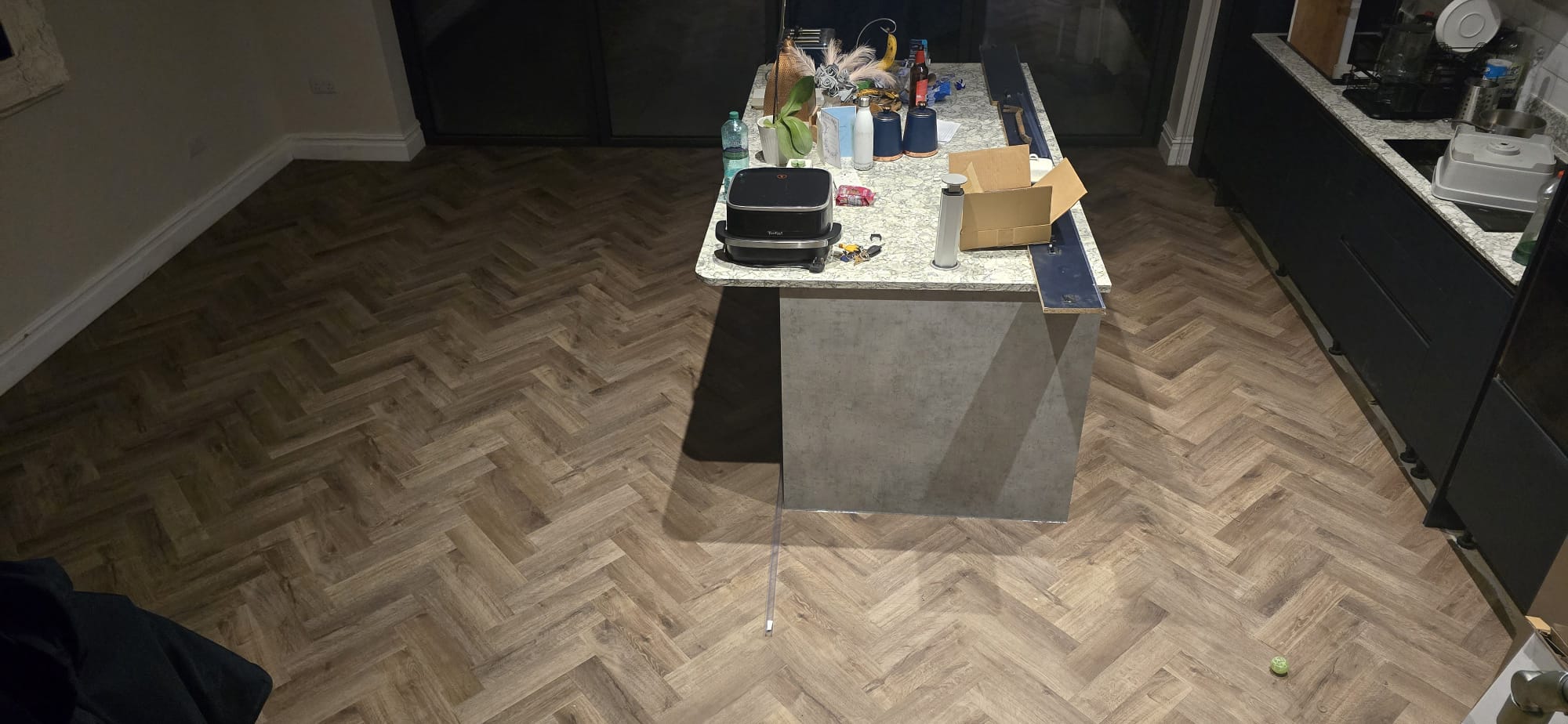 Oak herringbone LVT flooring fitted in a kitchen with an island unit in Northampton